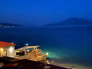 een huis met uitzicht op de oceaan in de nacht bij Passatempo Apartment Ireon in Samos