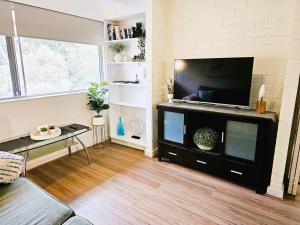 a living room with a flat screen tv on a entertainment center at The Parks Rosalie 32 - 1BRM Unit with Parking in Perth