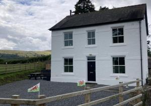 a white house with a fence in front of it at Llwyncelyn in Llangadog