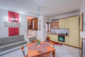 een keuken en een woonkamer met een tafel en een bank bij La Casa Del Saraceno in Civitavecchia