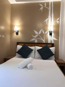 a bedroom with a white bed with two pillows at Anahaw Seaside Inn in Bantayan Island