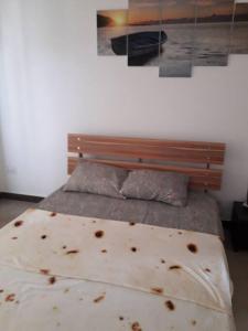 ein Schlafzimmer mit einem Bett mit einem Kopfteil aus Holz in der Unterkunft Arc en Ciel 1 - 3 bedrooms Private Appartment in Flic-en-Flac