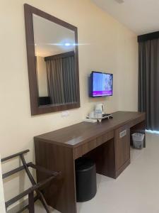 a desk in a hotel room with a mirror at Wang Valley Resort in Pantai Cenang