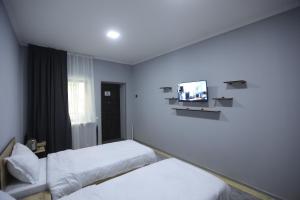 AngrenにあるEagle Rock Nature Lodgeのベッド2台、薄型テレビが備わるホテルルームです。