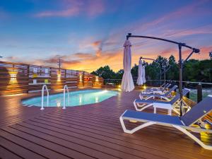 a deck with chairs and a swimming pool at sunset at Udoscape Eco-Glamping Resorts in Lago Vista