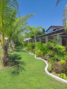 a path through a yard with palm trees and a building at Marand Beach Resort in Bauang