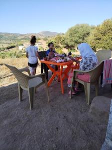 a woman and a child sitting at a table at Maison d'hôte Yeswal in Guezira +130 photos