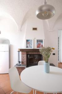 a white dining room with a white table and chairs at Villa San Pietro in Portovenere