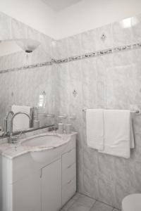 a white bathroom with a sink and a mirror at Villa San Pietro in Portovenere