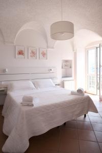 ein weißes Schlafzimmer mit einem großen Bett mit Handtüchern darauf in der Unterkunft Villa San Pietro in Porto Venere