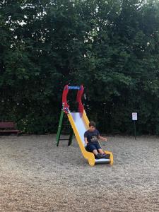 a boy sitting on a slide at a playground at CentROOM Nagykanizsa in Nagykanizsa