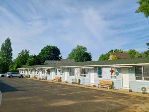 a white building with benches in a parking lot at Stop 21 Motel in Southampton