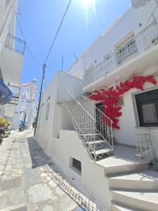 a white building with stairs on a street at Margaret's Houses in TINOS Town in Tinos Town