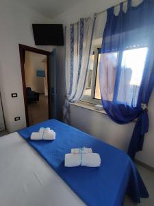 Un dormitorio con una cama azul con toallas. en Ely Sea 2, en Belvedere Marittimo