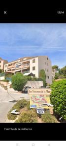 a street sign in front of a building at Charmant F3 lumineux proche plage et vue mer à Carqueiranne in Carqueiranne
