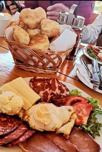 a table with a plate of food and a basket of bread at Rafting Camp Konak in Foča