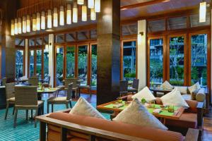 un restaurante con mesas, sillas y ventanas en Marriott's Mai Khao Beach - Phuket en Mai Khao Beach