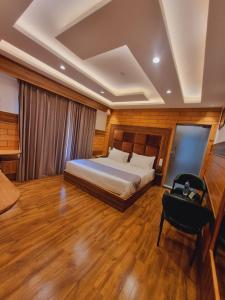 a bedroom with a bed and a desk and a chair at White Water Resorts in Pahalgām