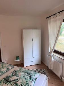 1 dormitorio con 1 cama, armario y ventana en Apartment Mahira im Luftkurort Schindeldorf, en Stromberg