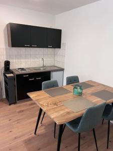cocina con mesa de madera con sillas y fregadero en Apartment Mahira im Luftkurort Schindeldorf, en Stromberg