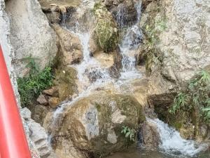 a waterfall on the side of some rocks at Hotel Red Roof & Restaurant in Abbottabad