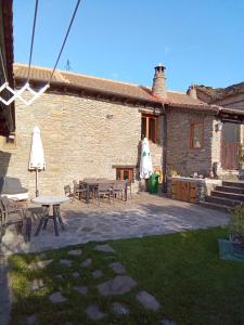 a patio with tables and chairs in front of a building at La Borda de Allué in Huesca