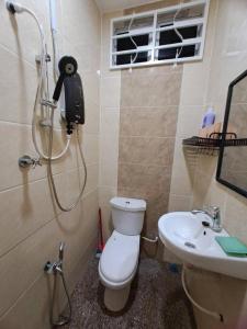 a bathroom with a shower and a toilet and a sink at Homestay Jeli - Cattleya Inn Muslim in Jeli