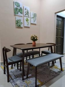 uma mesa de jantar com cadeiras e uma mesa com uma planta em Homestay Jeli - Cattleya Inn Muslim em Jeli