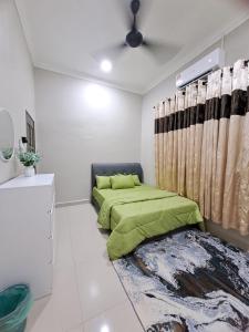 sypialnia z zielonym łóżkiem i zasłoną w obiekcie Homestay Jeli - Cattleya Inn Muslim w mieście Jeli