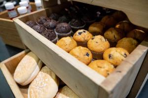 two wooden boxes filled with different types of muffins at Holiday Inn Express Manchester City Centre Arena by IHG in Manchester