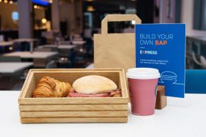 a box of bread and croissants and a cup of coffee at Holiday Inn Express Manchester City Centre Arena by IHG in Manchester