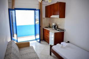 a small kitchen with a couch and a window at Zorbas Studios in Agia Roumeli +65 photos