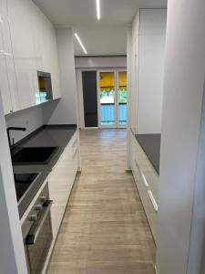 una cucina con armadietti bianchi e pavimenti in legno di Casa vacanze Collina d'oro a Montagnola