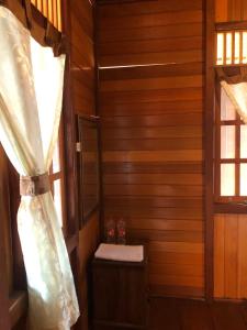 een kleine kamer met houten wanden en een raam bij Roemah Kayu Saragan Syariah Magelang Mitra RedDoorz 