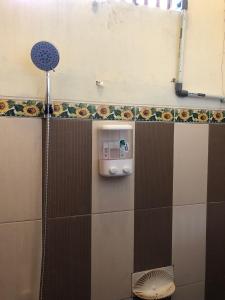 a shower stall with a soap dispenser on a wall at Roemah Kayu Saragan Syariah Magelang Mitra RedDoorz 
