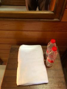 een tafel met een handdoek en twee flessen erop. bij Roemah Kayu Saragan Syariah Magelang Mitra RedDoorz 