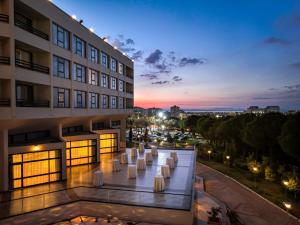 a view of a building at night with white chairs at Kaya Izmir Thermal & Convention in Izmir