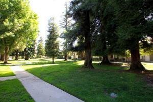 a park with trees and a sidewalk in the grass at Townhouse Suite by FSU SaveMartCenter in Fresno