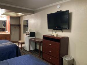 a hotel room with a flat screen tv on the wall at Little Boy Blue Motel in Anaheim
