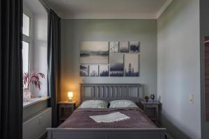 a bedroom with a bed with pictures on the wall at Ferienwohnung Weitblick in Naumburg