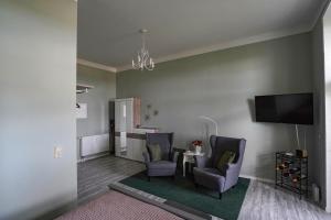 a living room with two chairs and a table and a tv at Ferienwohnung Weitblick in Naumburg