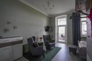 a living room with two chairs and a tv at Ferienwohnung Weitblick in Naumburg
