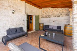 eine Terrasse mit 2 Sofas, einem Tisch und Weinfässern in der Unterkunft Villa Damiana in Petrići