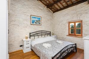 ein Schlafzimmer mit einem Bett in einem Zimmer mit Ziegelwand in der Unterkunft Villa Damiana in Petrići