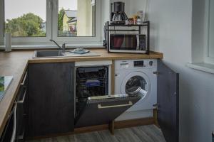 a washing machine in a kitchen with a microwave at Ferienwohnung Weitblick in Naumburg