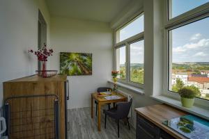 a dining room with a table and two windows at Ferienwohnung Weitblick in Naumburg