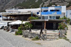 a building on the side of a beach with a building at Zorbas Studios in Agia Roumeli