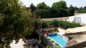een uitzicht over het zwembad in de tuin bij le Mas d'Hubert in LʼIsle-sur-la-Sorgue