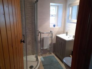 Un baño con ducha, inodoro y lavabo. en Moira Cottages @Berwickhall Sleeps 12, en Moira