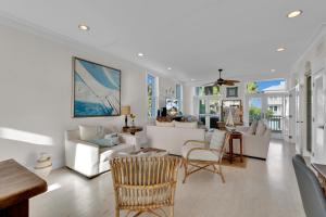 una sala de estar con muebles y ventanas blancos. en Lotus Villa - Private beach house with Pool and Hot Tub home, en South Padre Island